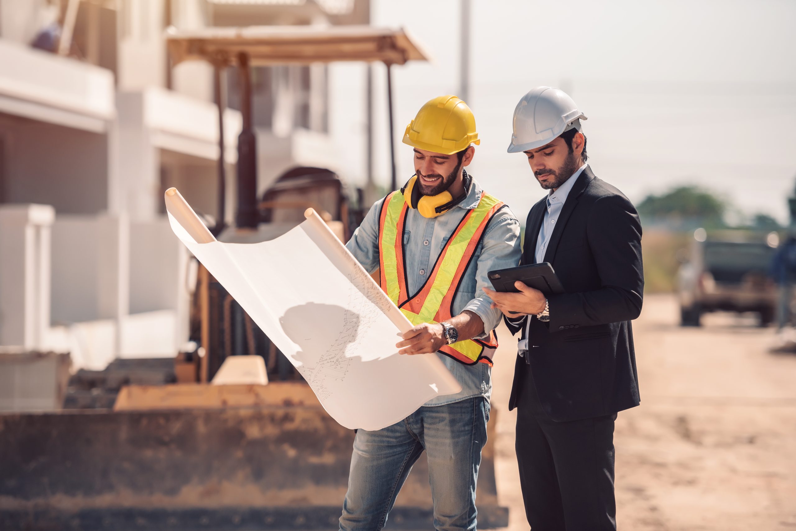 Building Homes Civil engineer and construction worker manager holding digital tablet and blueprints , talking and planing about construction site.  Cooperation teamwork concept.